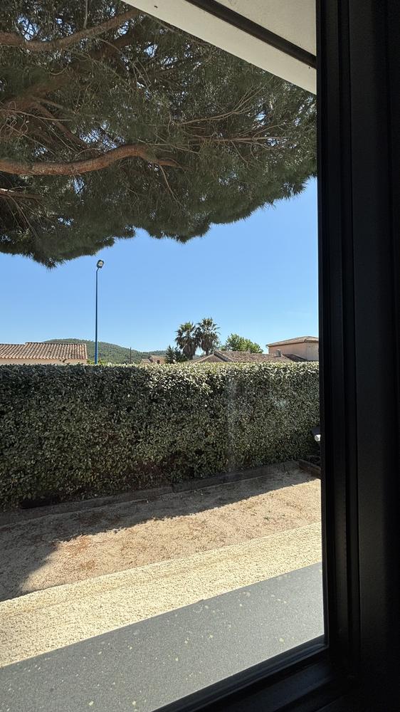 Baie vitrée de villa à Carqueiranne après nettoyage, vue dégagée sur le jardin et la haie