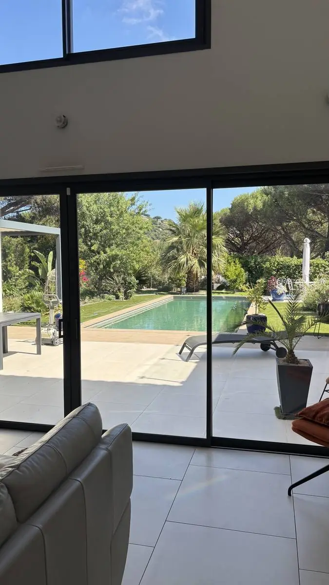 Baie vitrée de villa à Ramatuelle donnant sur piscine et jardin, nettoyée par PluPropre